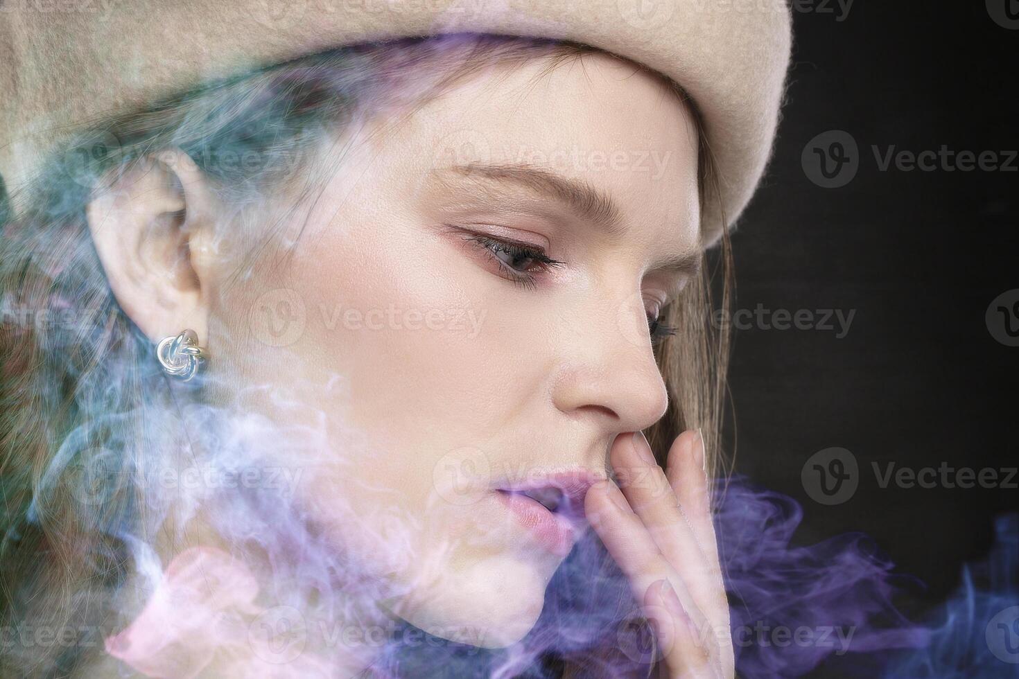 The girl's face close-up in profile in colored smoke. photo