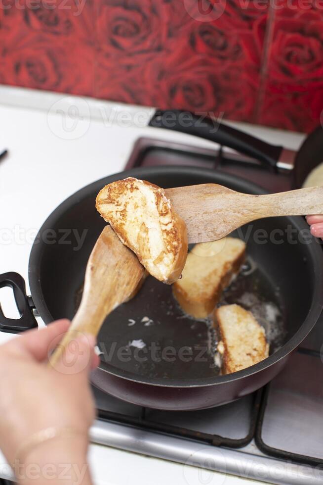 Fry white loaf croutons in a frying pan. Cook breakfast. photo