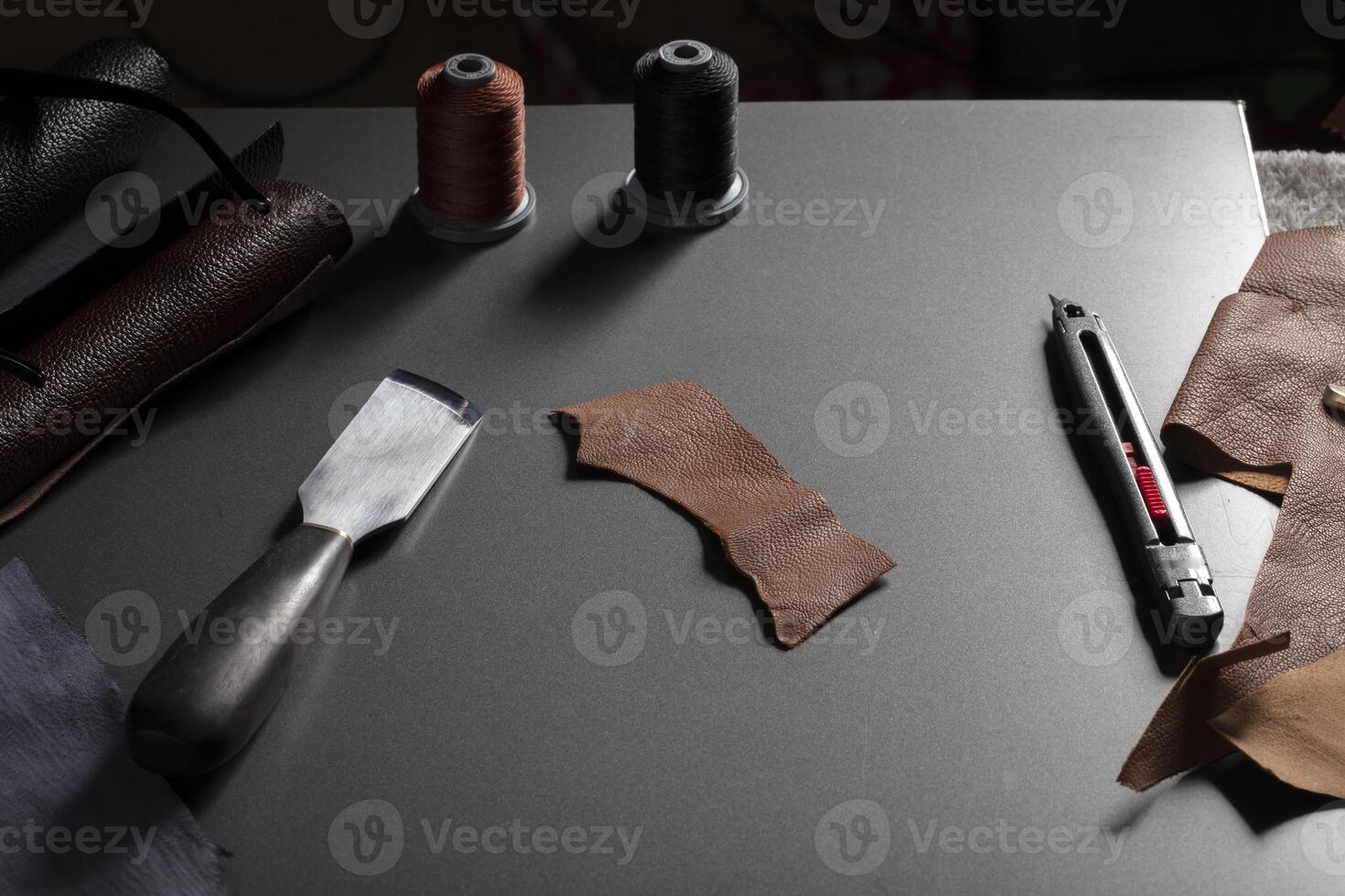 Work table with the tool of a craftsman for the manufacture of leather goods. photo