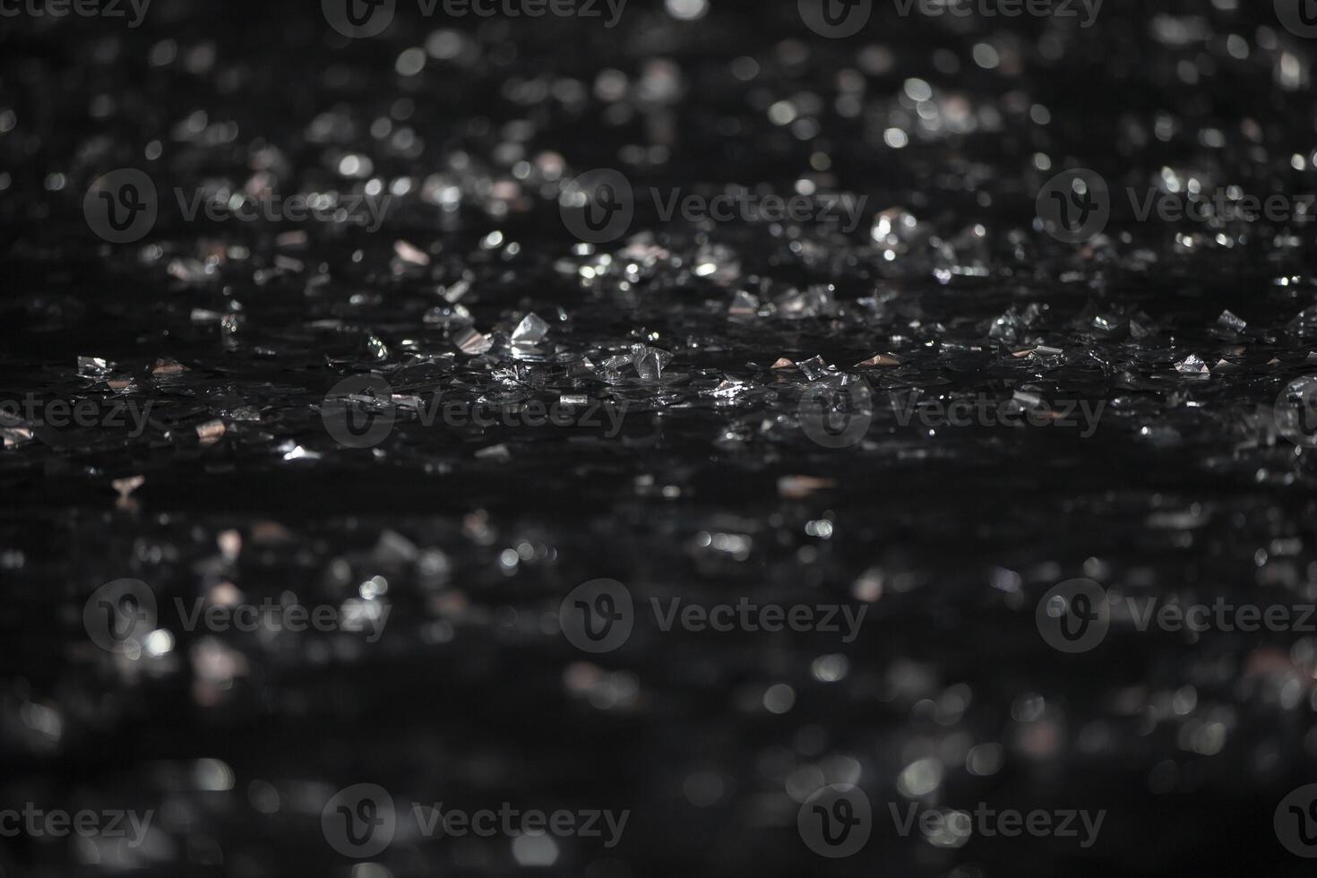 On a black background there are silver bokeh spots from shiny confetti. photo