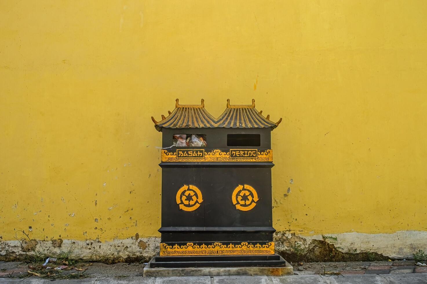 trash cans with Chinese-style designs that are differentiated into dry waste and wet waste in China Town with a yellow wall background, Indonesia, 17 September 2023. photo