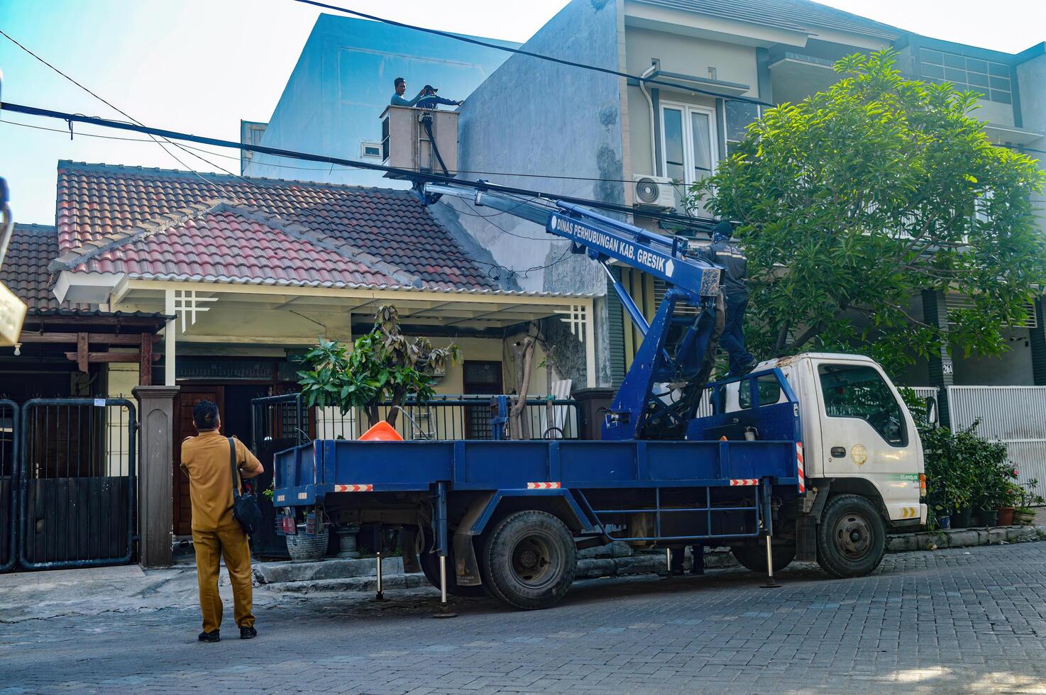 The Public Works Department is organizing messy telecommunications and electrical cables using a sky lift car, Indonesia, 19 December 2023. photo