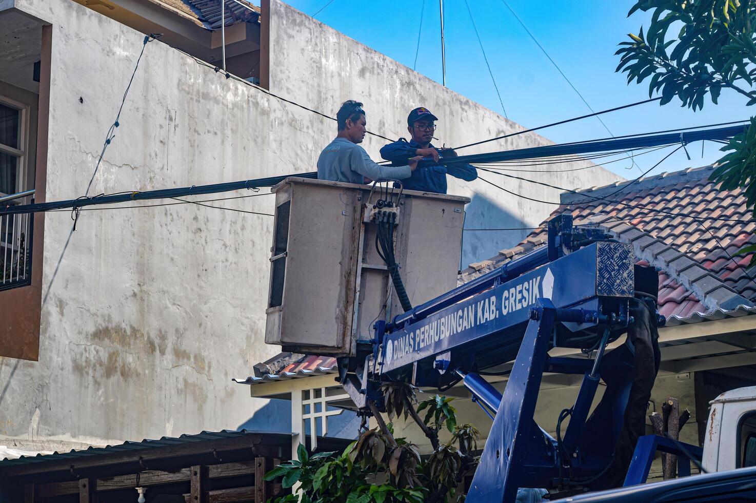 The Public Works Department is organizing messy telecommunications and electrical cables using a sky lift car, Indonesia, 19 December 2023. photo