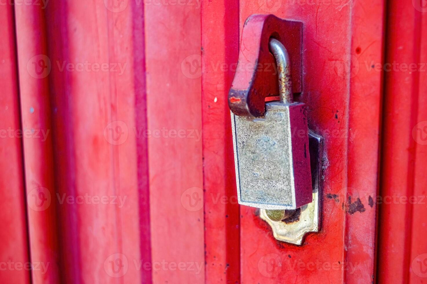 a locked padlock on the red iron harmonica door photo