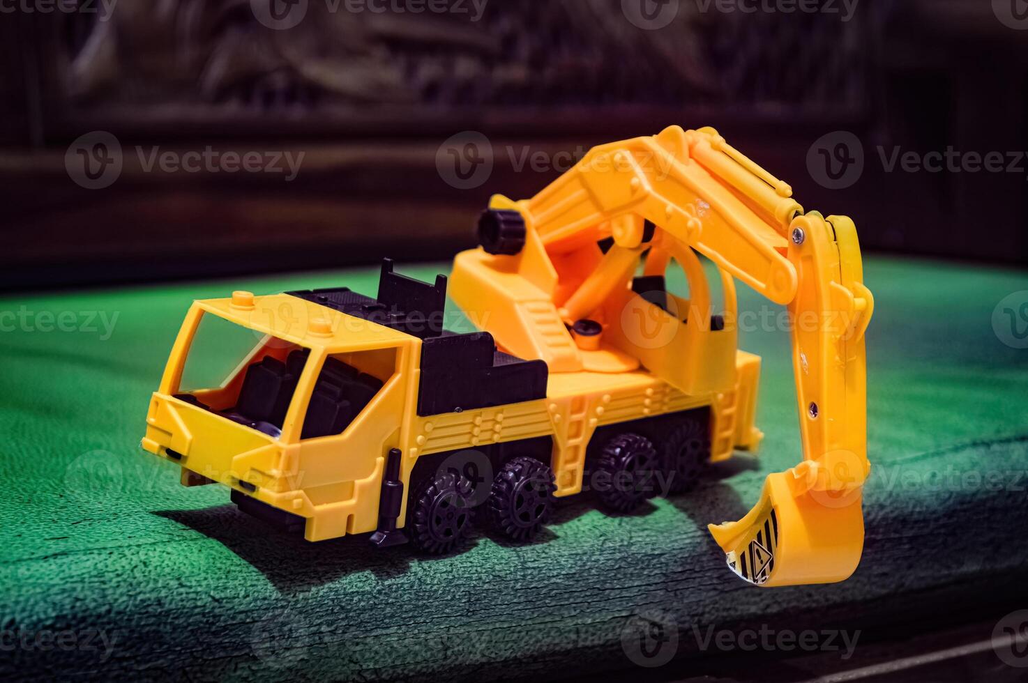 a yellow miniature excavator toy on the sofa photo