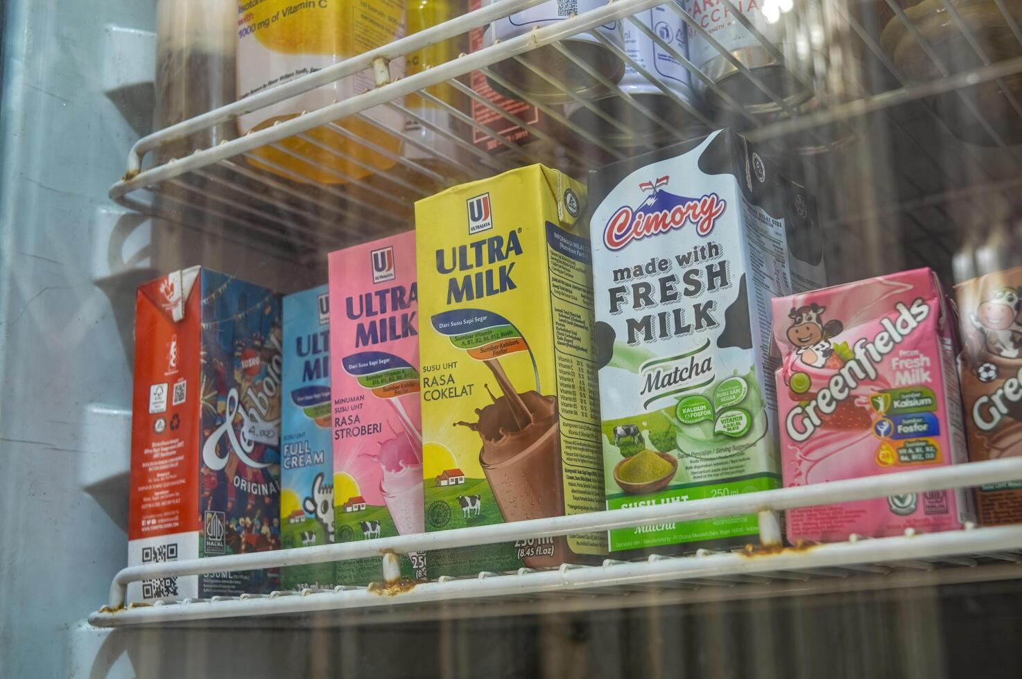 rows of packaged drinks in the display case refrigerator consisting of boxed milk and boxed tea, Indonesia, 19 October 2023. photo