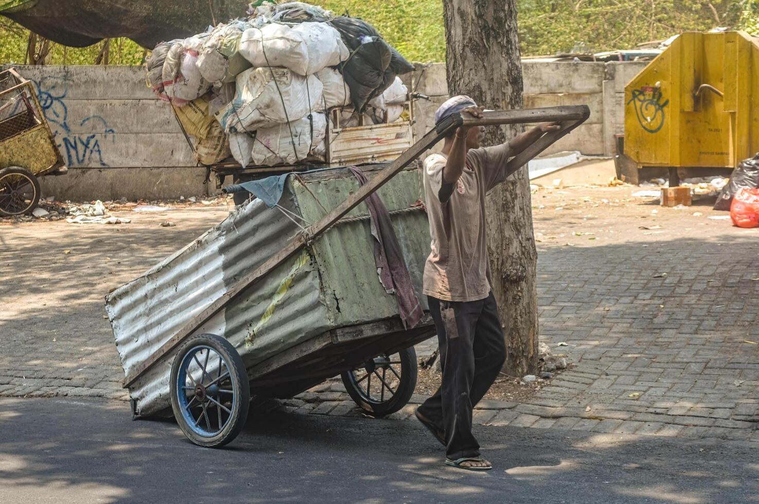 a scavenger who pulls a rubbish cart in front of a rubbish dump, Indonesia, 2 November 2023. photo