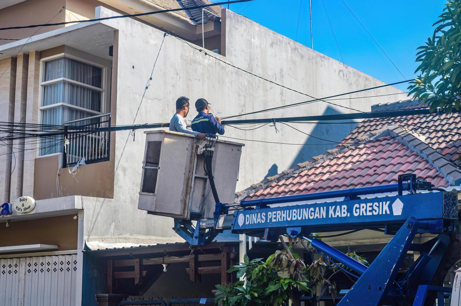 The Public Works Department is organizing messy telecommunications and electrical cables using a sky lift car, Indonesia, 19 December 2023. photo
