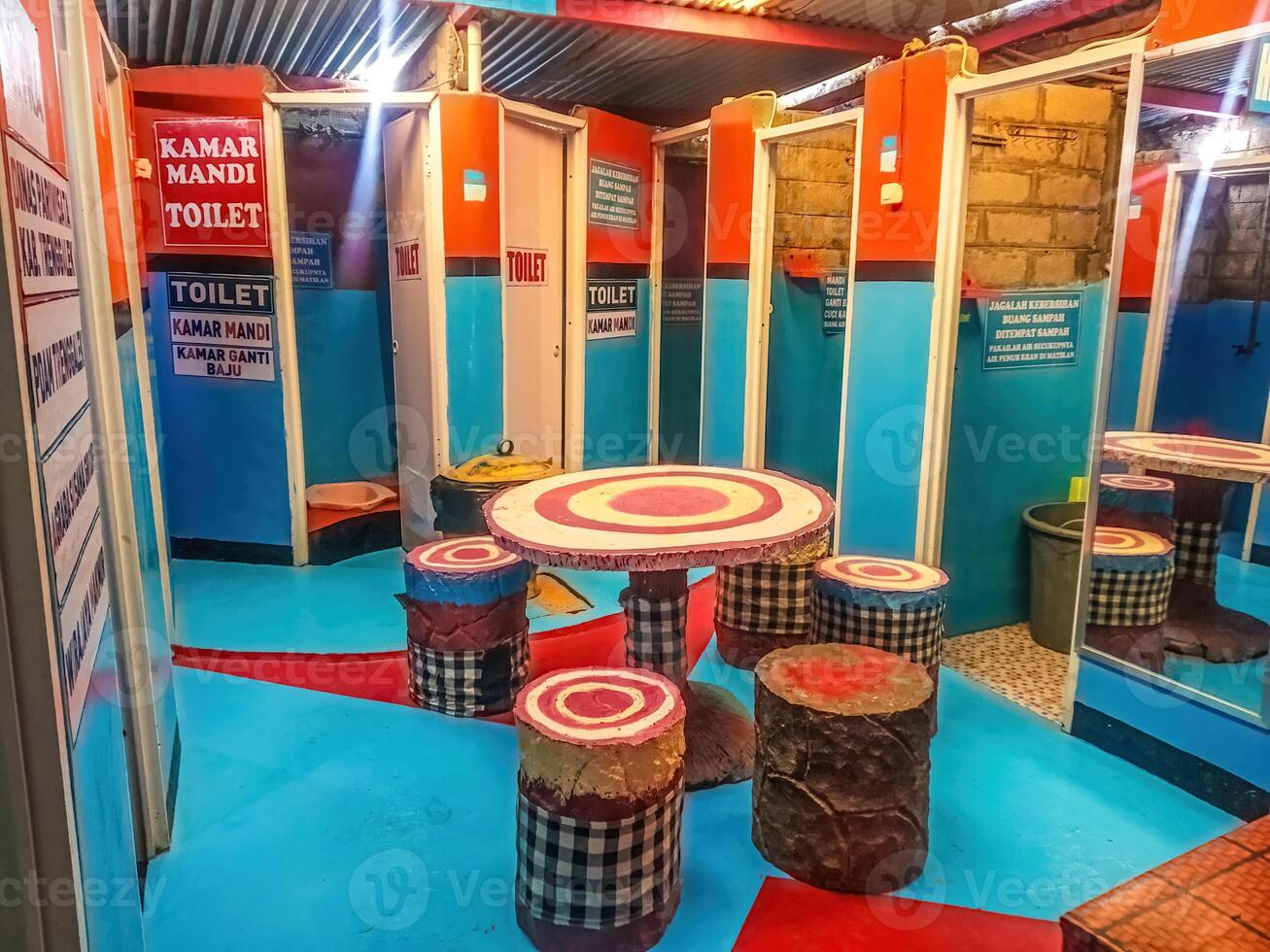 A cute and colorful aesthetic public toilet with circle tables and chairs looks like a cafe. photo