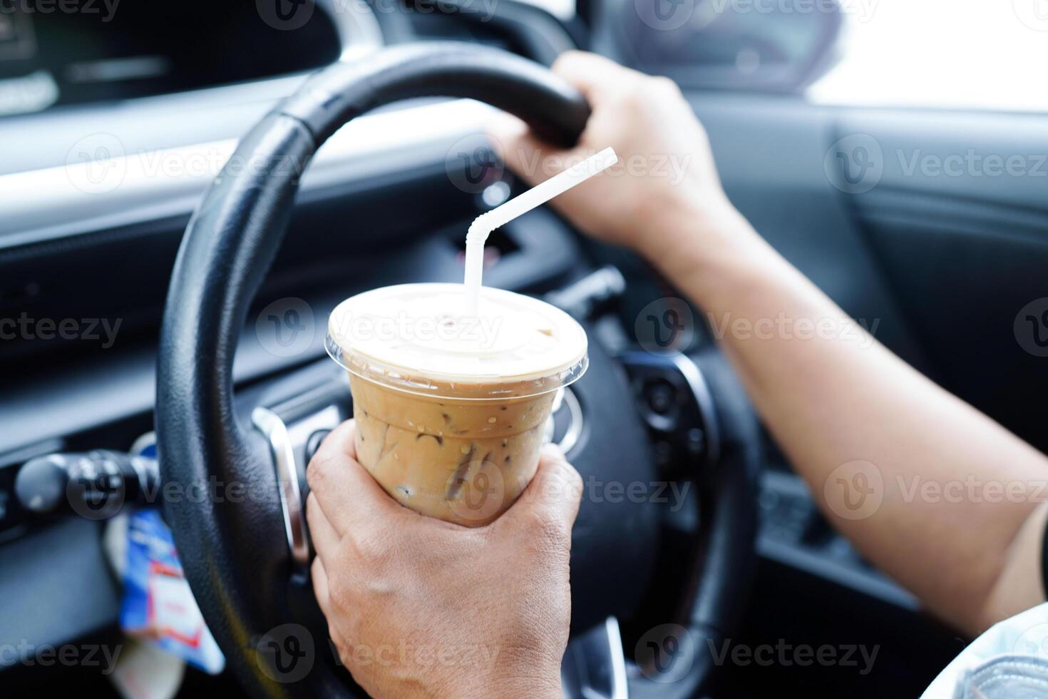 Asian woman driver hold drink in car, dangerous and risk an accident. photo