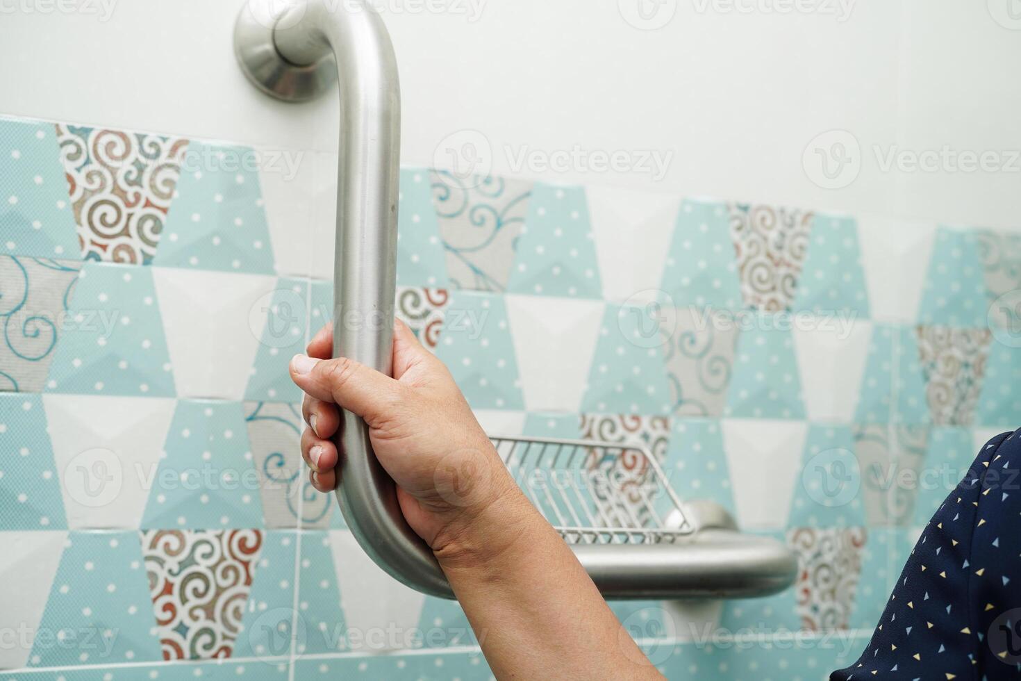 Asian woman patient use toilet support rail in bathroom, handrail safety grab bar, security in nursing hospital. photo