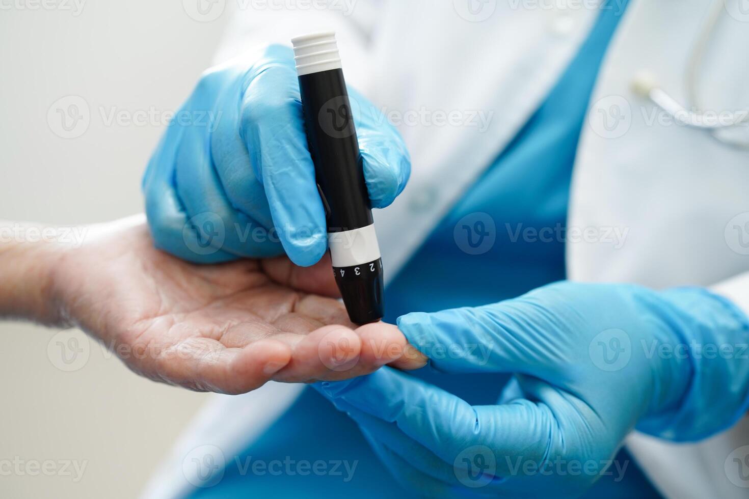 Asian doctor using lancet pen on senior patient finger for check sample blood sugar level to treatment diabetes. photo