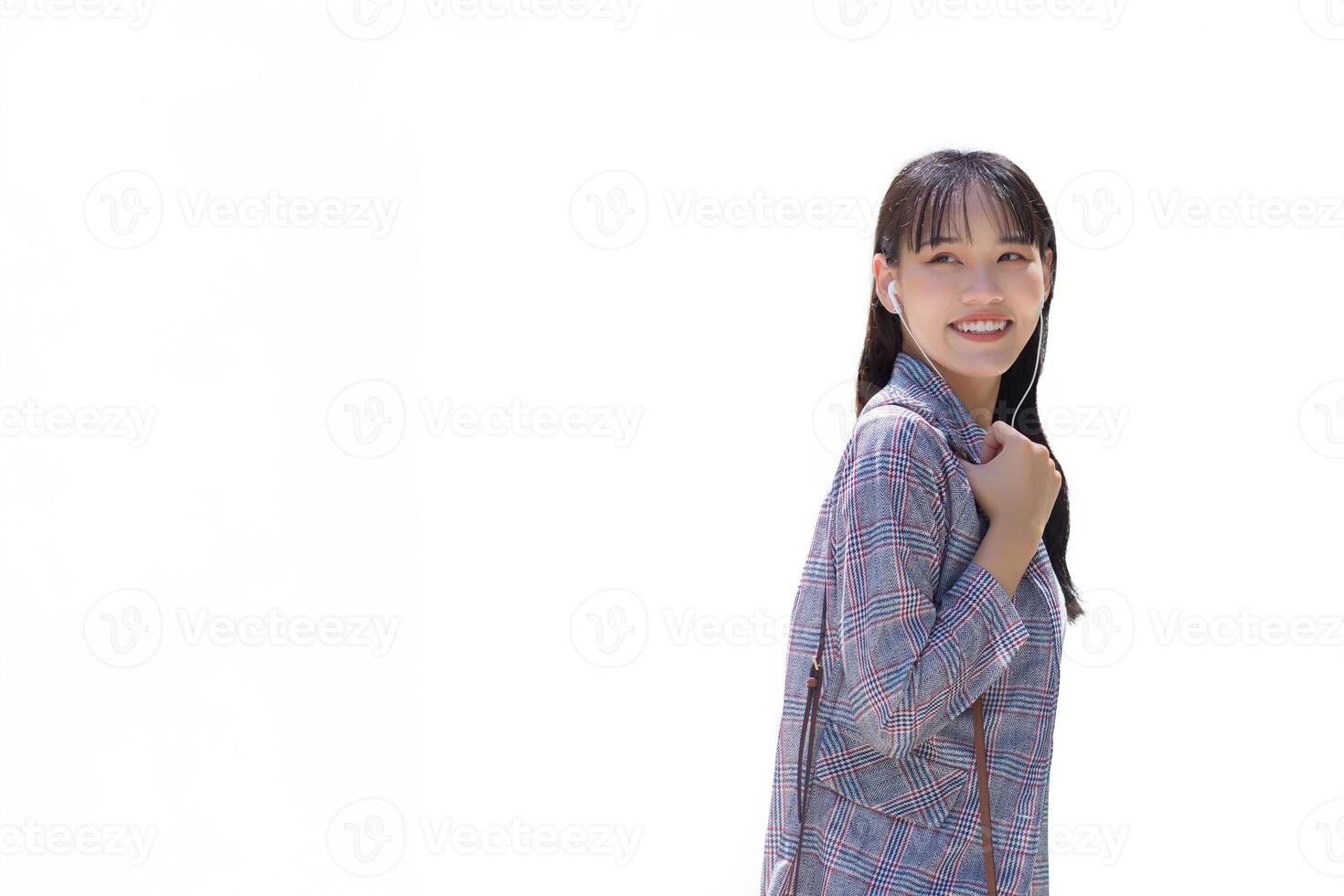 confidente joven negocio asiático trabajando mujer quien usa gris a rayas chaqueta de sport mientras utilizando teléfono inteligente con pequeño hablar sonrisas como ella conmutar a trabajo mediante ciudad mientras aislado blanco antecedentes. foto