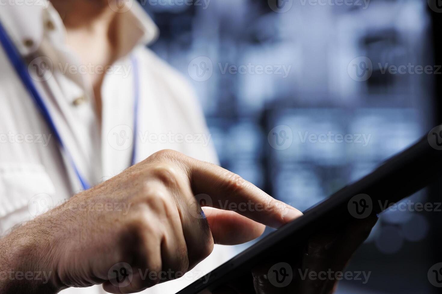 Qualified electrician inspects server rows in computer network security data center, ensuring optimal performance. Certified wireman monitoring energy consumption across infrastructure parts, close up photo