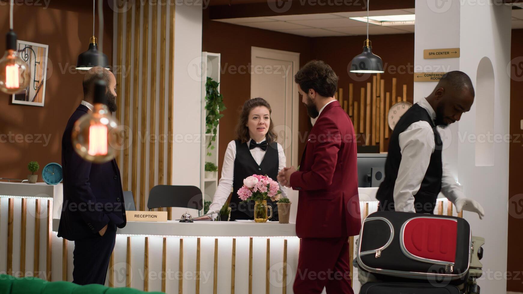 Hotel staff offering luxury services to businessmen guests at resort, travelling on business trip and attending international conference. Managers team doing check in at front desk reception. photo