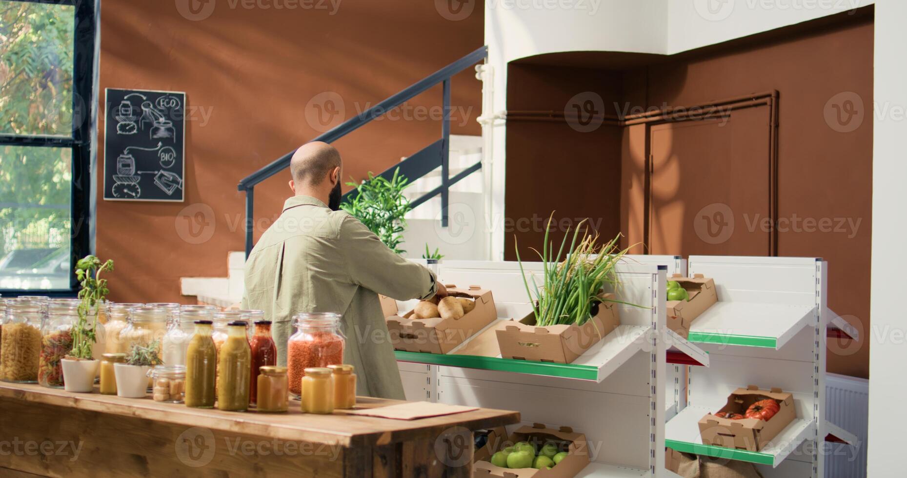 Client choosing bio produce to buy, approaching checkout counter to pay for bag filled with organic freshly harvested vegetables. Person going shopping for groceries at local natural market. photo