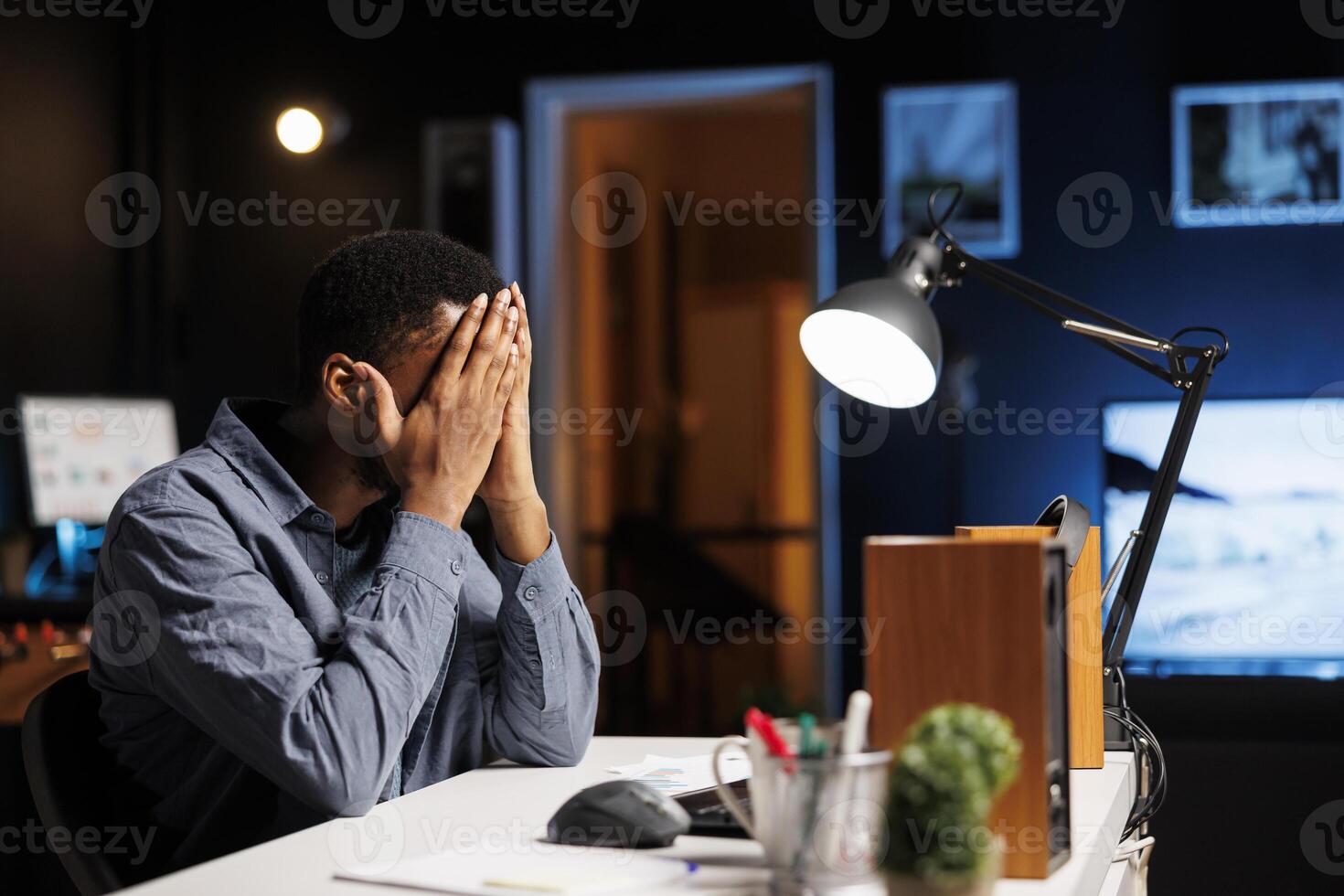 Researcher exhausted after working overtime to finish analysis on schedule. African American feeling under pressure with stress from the leadership team, overcome major difficulties remotely. photo