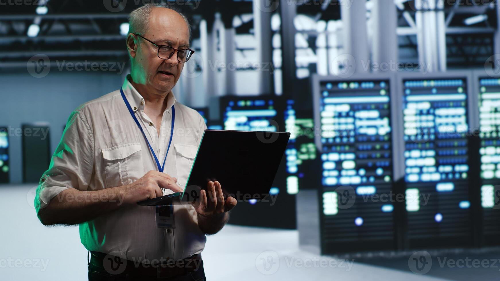Skillful IT professional navigating network of servers in industrial facility. Developer with laptop in hand ensuring seamless operations, doing optimizations and maintenance in data center photo