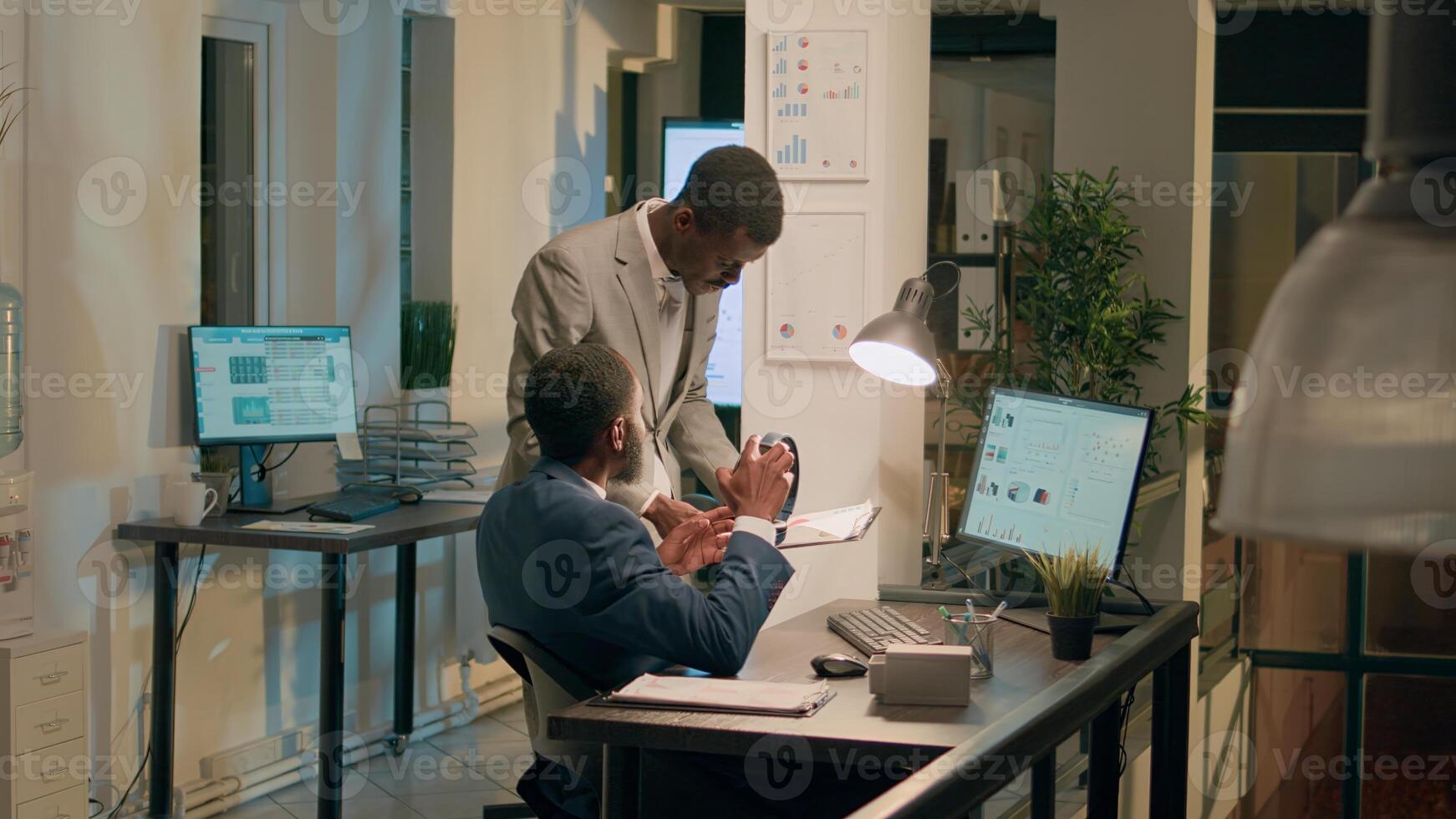 Manager annoyed by unattentive employee listening to music at work, upset about project mistakes he did. Management executive displeased by worker lack of focus in office during nightshift photo