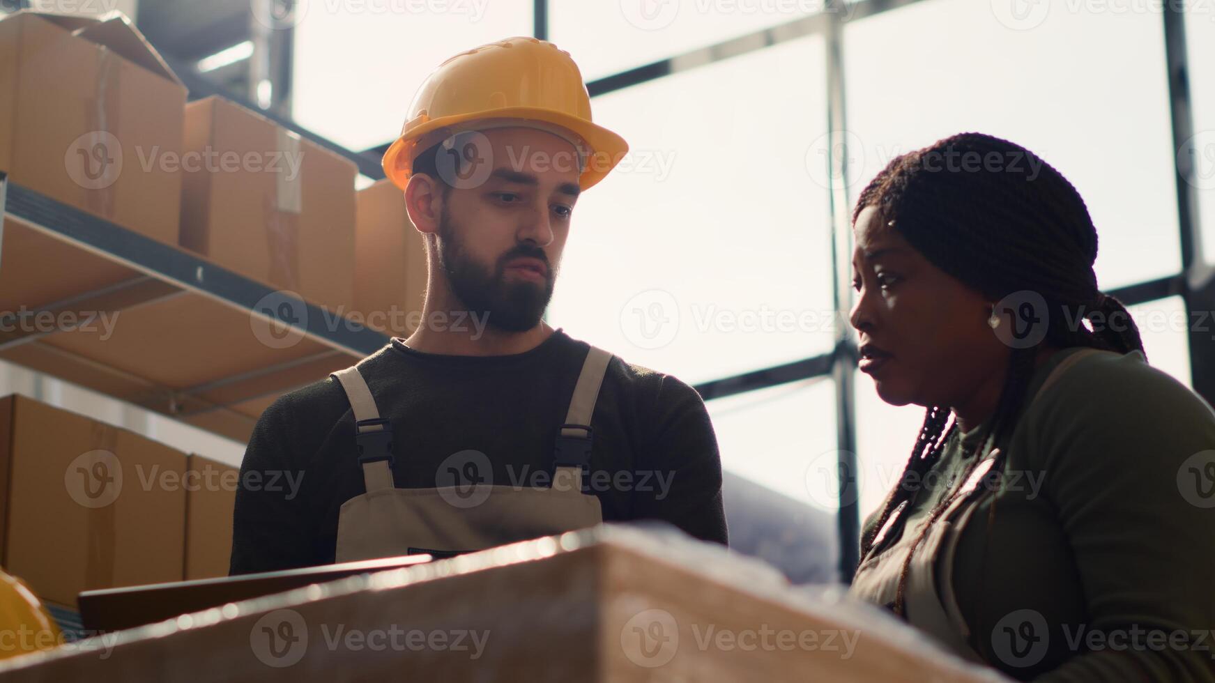 Warehouse team leader doing introduction training to new intern starting job, teaching him safety measures around storage area aisles. Manager does induction tutorial for intern photo
