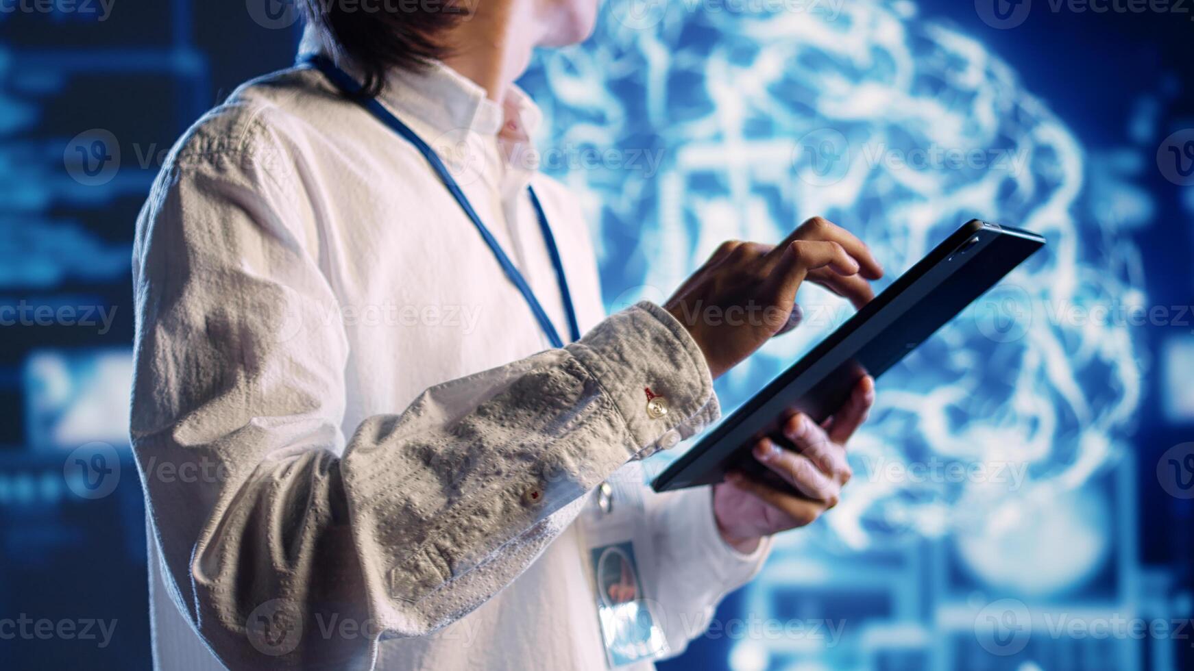 Knowledgeable developer in data center uses artificial intelligence computing simulating human brain thought processes. Proficient expert works on tablet with AI machine learning algorithms photo