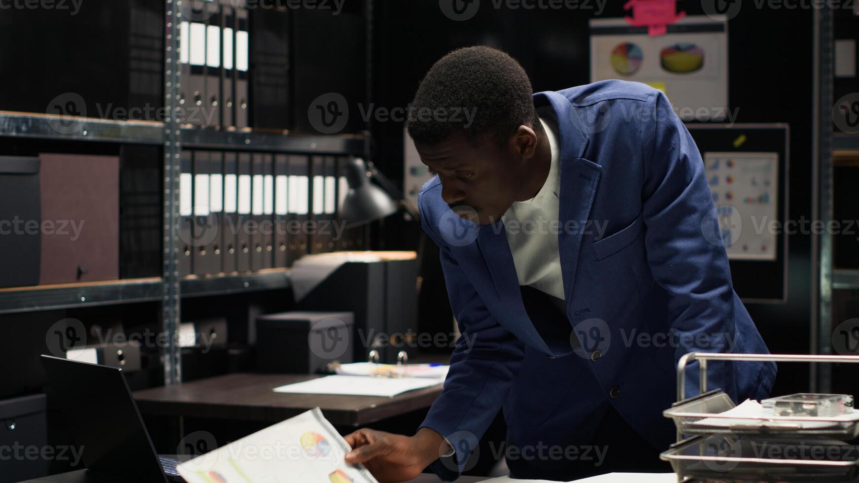 African american male investigator analyzes evidence and conducts a confidential investigation. Black man with expertise in criminology reviews forensic files and classified research information. photo