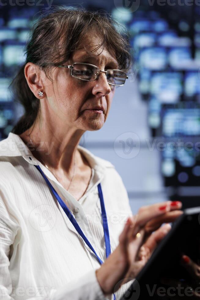 Seasoned wireman preparing cloud computing business recovery plan, monitoring data center energy consumption across parts, making sure sensors are in ideal condition, doing annual disk checks photo