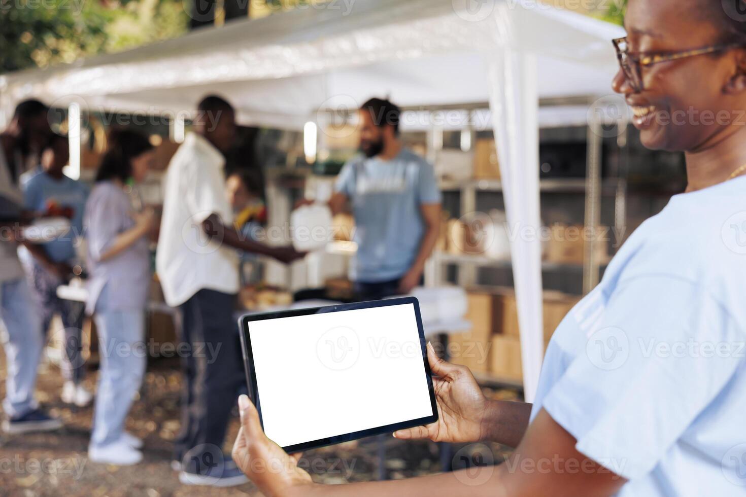 Image shows friendly african american lady carrying tablet with copyspace mockup template for customizable charity notes. Smiling woman horizontally grasps digital device with isolated white screen. photo