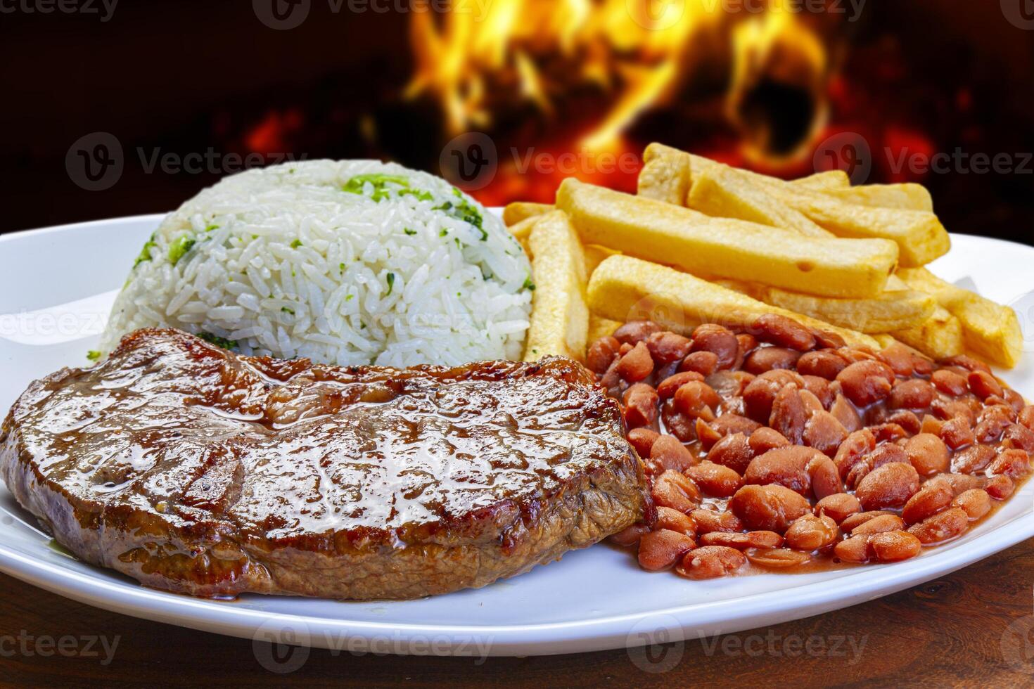 Grilled steak meat, rice, beans and french fries photo