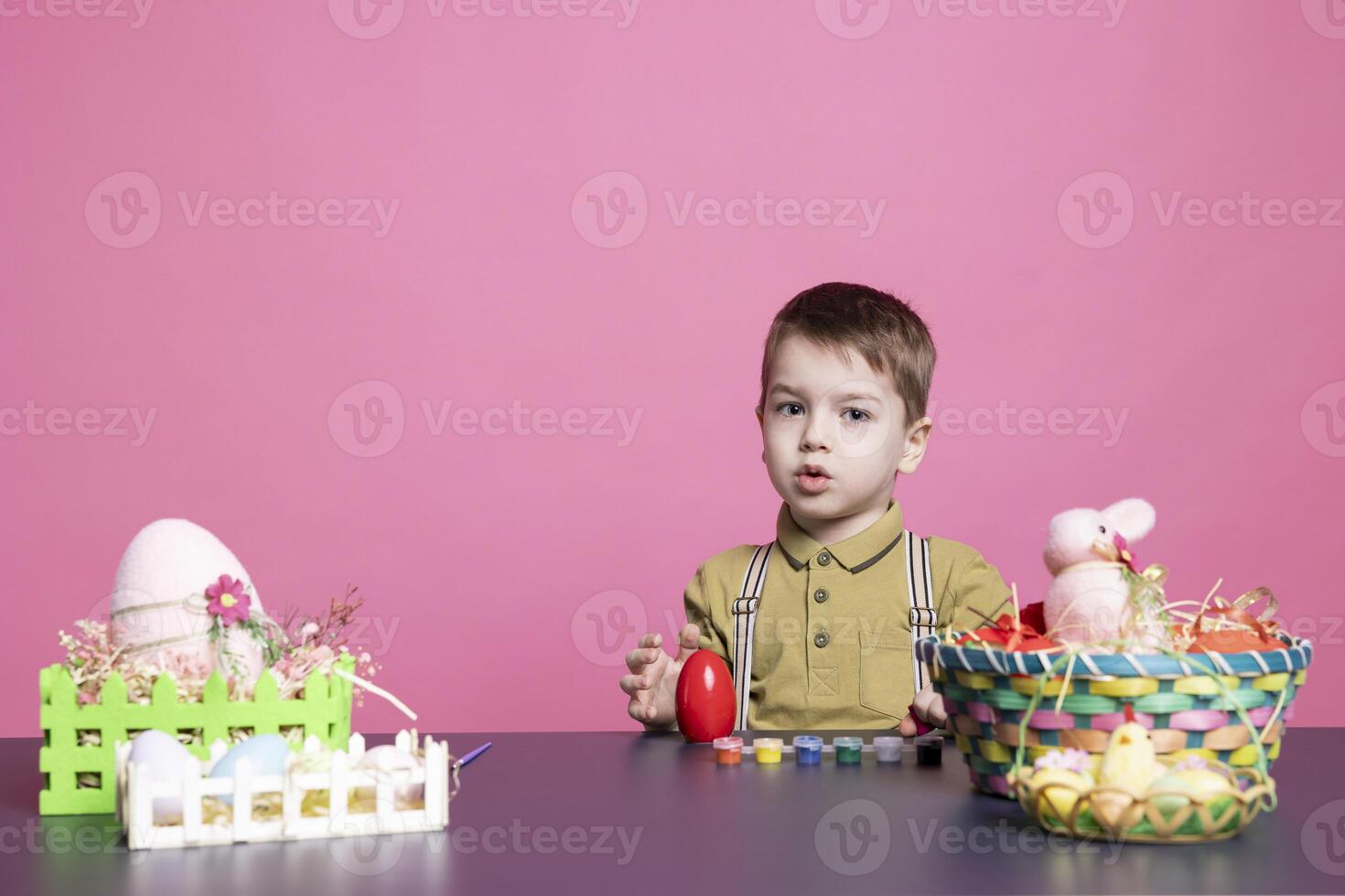 Sweet little boy having fun decorating eggs with stamps and watercolor, painting festive decorations for easter sunday holiday. Adorable toddler enjoys decorating activity with craft tools. photo