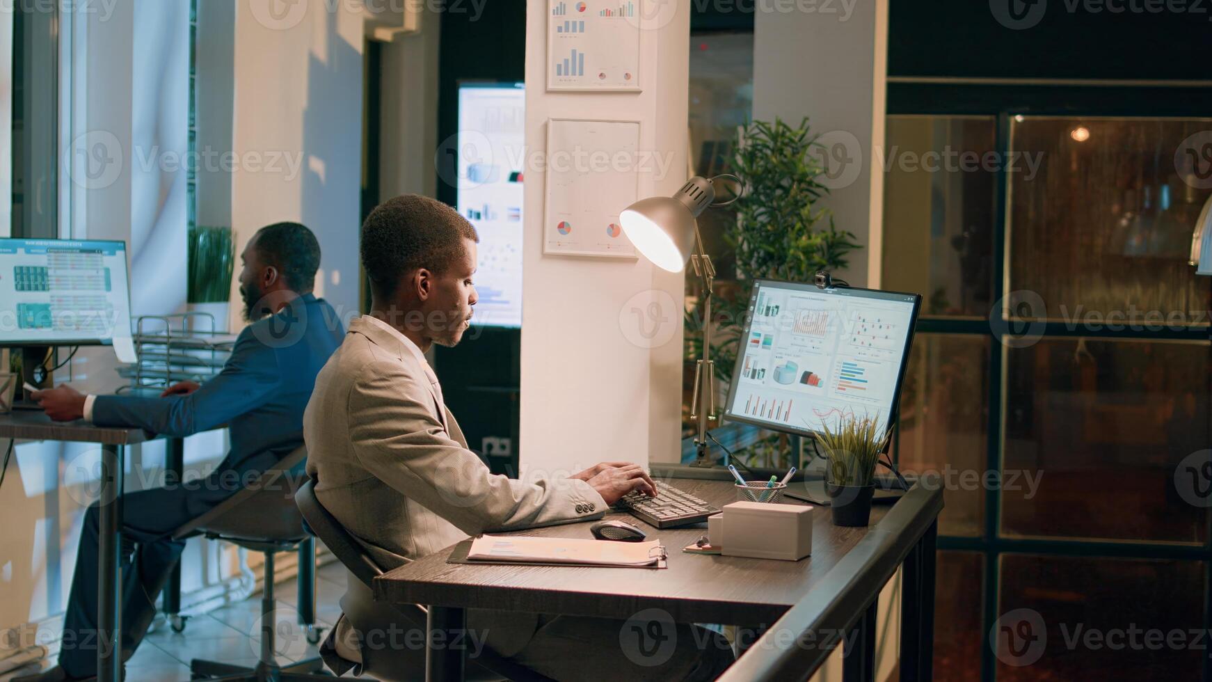 Employees working together overnight on finishing project before impending next day deadline. Hardworking office staff members solving various company project tasks during nightshift photo