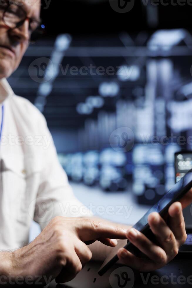 Computer scientist coding in high tech data center using javascript language, close up. Skillful worker updating software on server rigs on tablet terminal, ensuring optimal performance and security photo