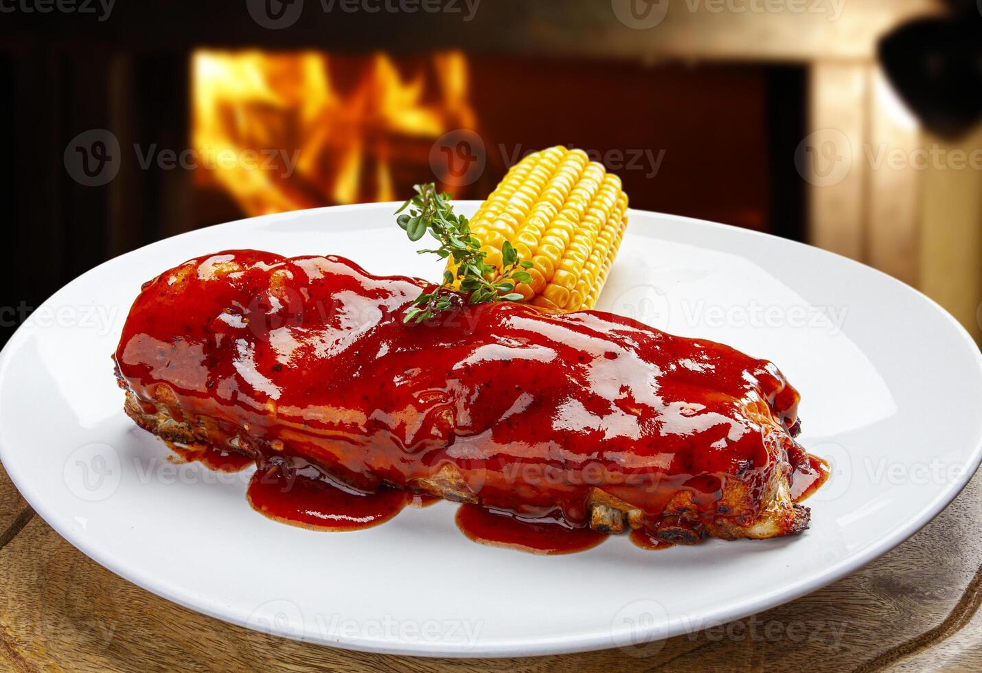 Roasted pork ribs with barbecue sauce and green corn photo