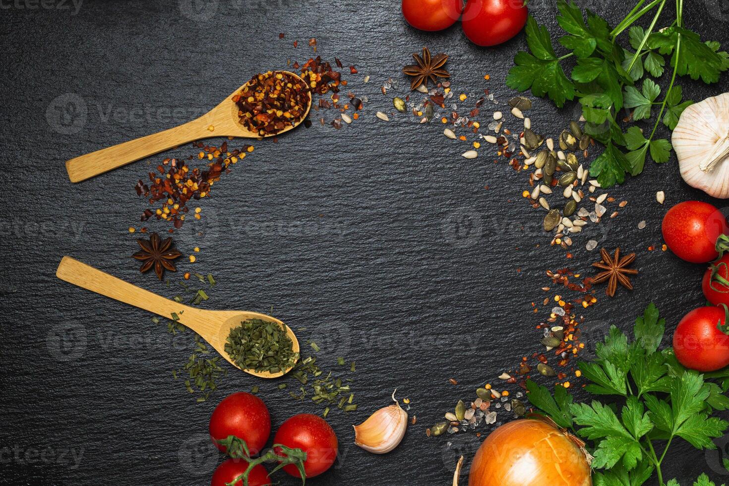 Different kind of spices frame on a black stone background photo