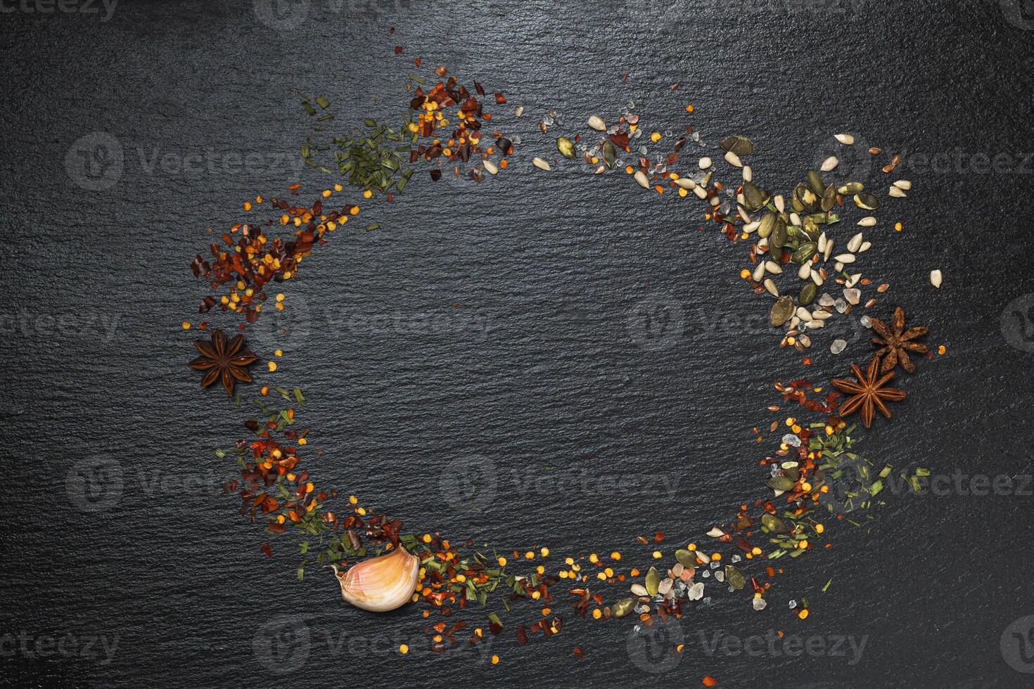 Pattern of spices on a black background. A set of spices from India. Decoration design. Various spices, peppers and herbs close-up top view. A set of peppers and spices for cooking. photo