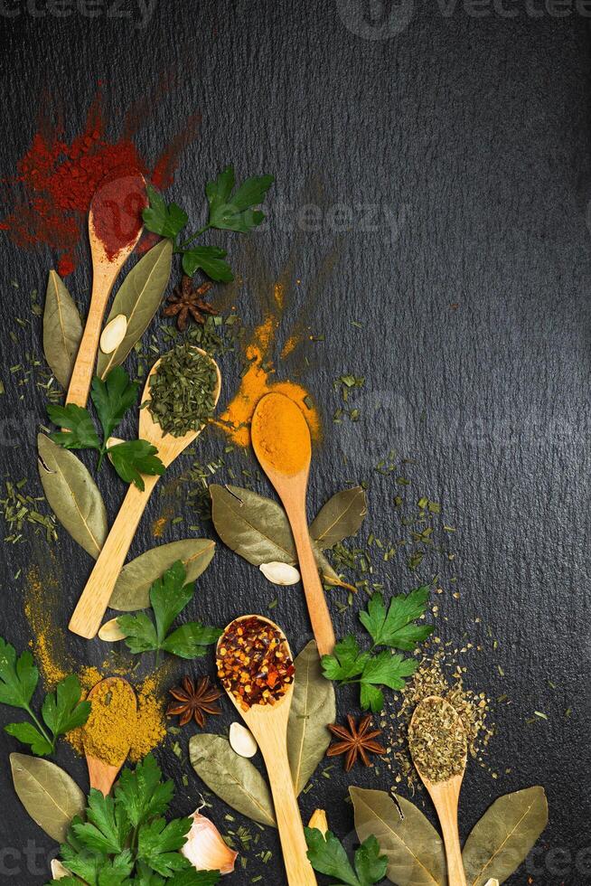 Kitchen cooking background spices and herbs. On a black background. photo