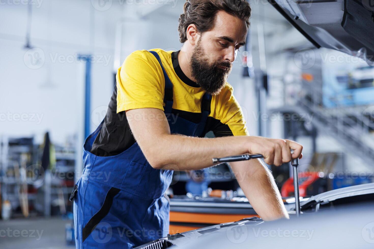 reparador en coche Servicio usos esfuerzo de torsión llave inglesa a apretar tornillos después reemplazando compresor cinturón. entrenado auto reparar tienda trabajador usos profesional herramientas a reparar cliente automóvil foto