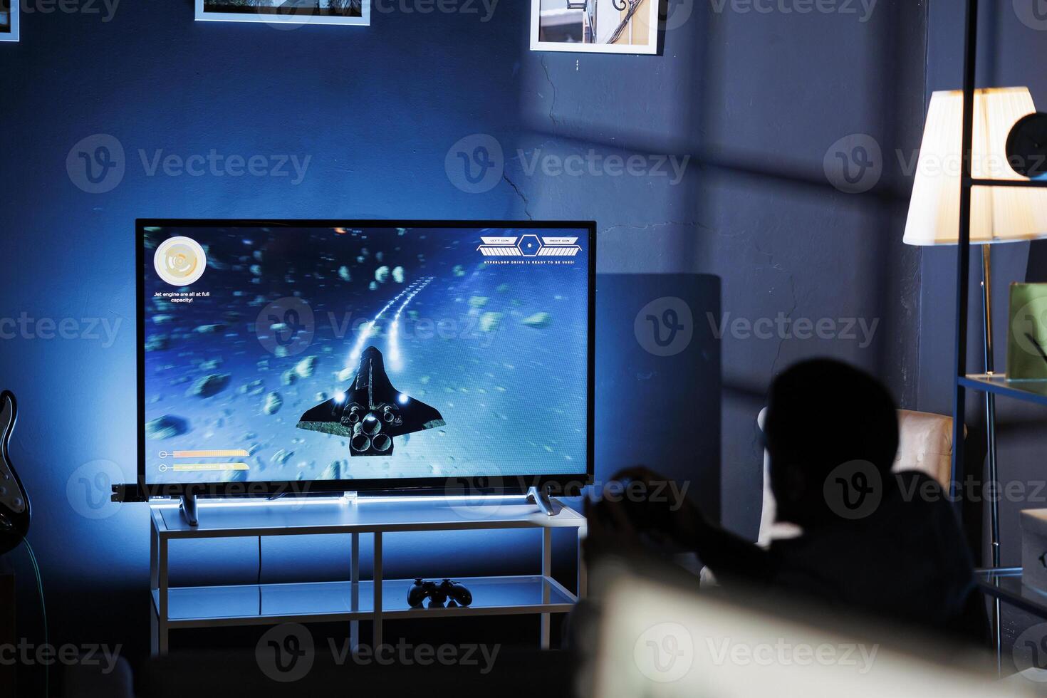 Young guy having fun with video games on television, connecting his console on tv in living room and enjoying chill game night at home. African american gamer playing first person tournament. photo