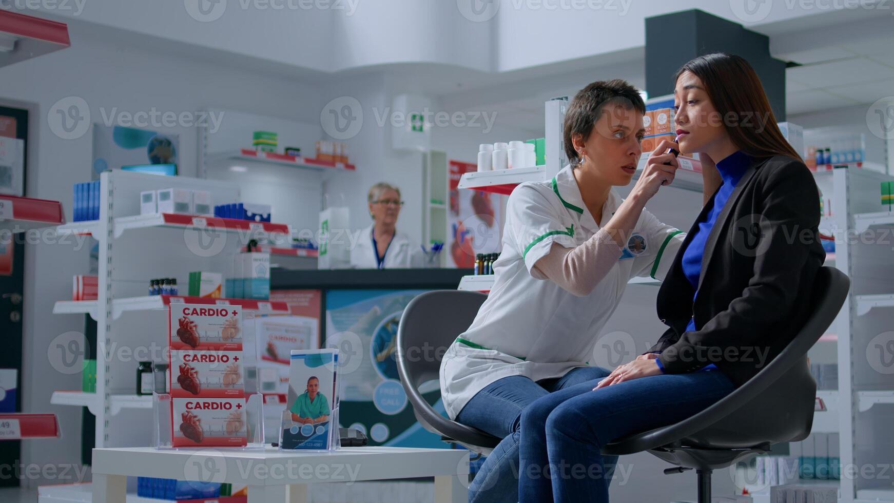 Pharmacist in drugstore doing annual patient checkup, using otoscope to examine ear cannal in professional consultation, preventing hearing loss, infections and other issues photo