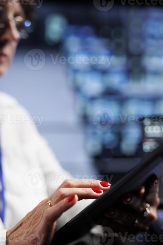 Close up of senior technician writing script code in high tech facility on laptop terminal. Focused supervisor doing maintenance work in data center, updating servers software to prevent malfunctions photo