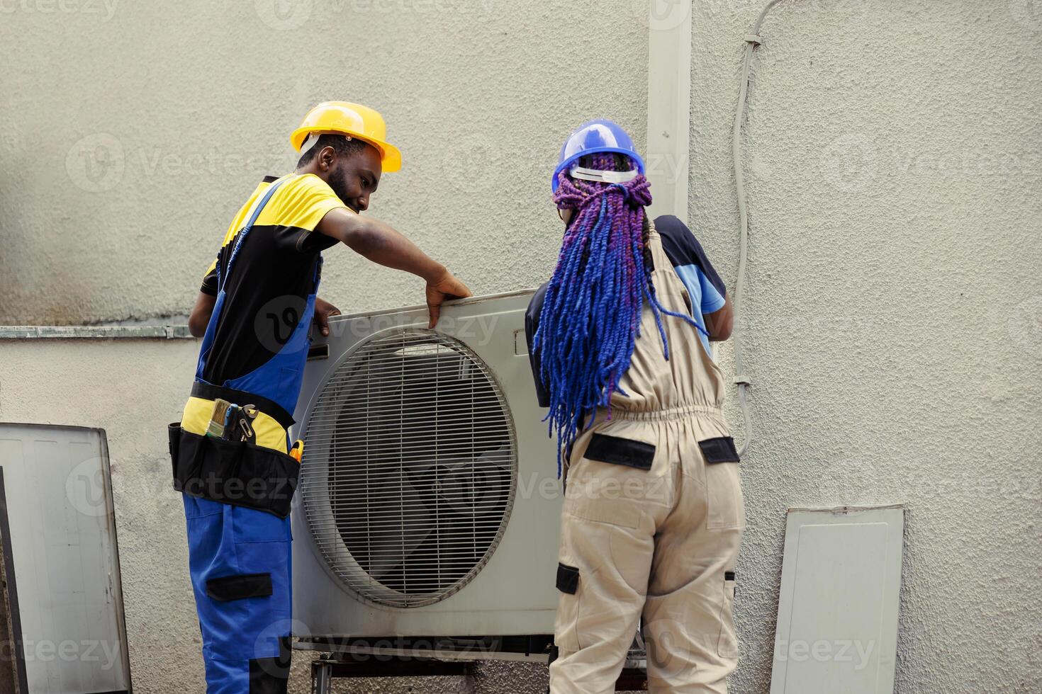 African american expert repairmen pulling apart air conditioner panel with industry techniques and equipment to mend air filters, electrical system issues and frozen evaporator coils photo