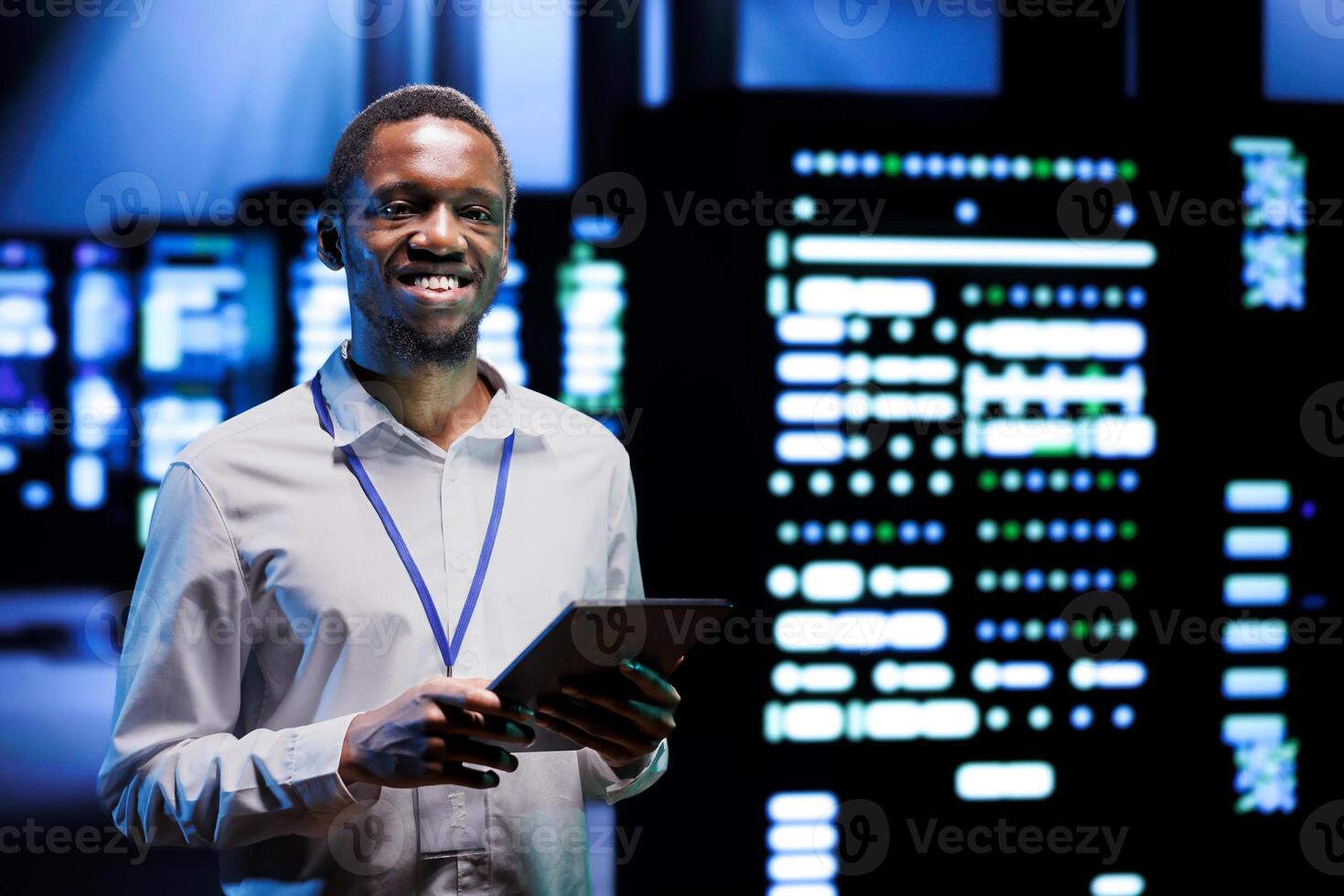 Portrait of smiling overseerer running data center devices diagnostic tests to determine and debug software problems. Happy serviceman using tablet to analyze critical systems, checking for crashes photo