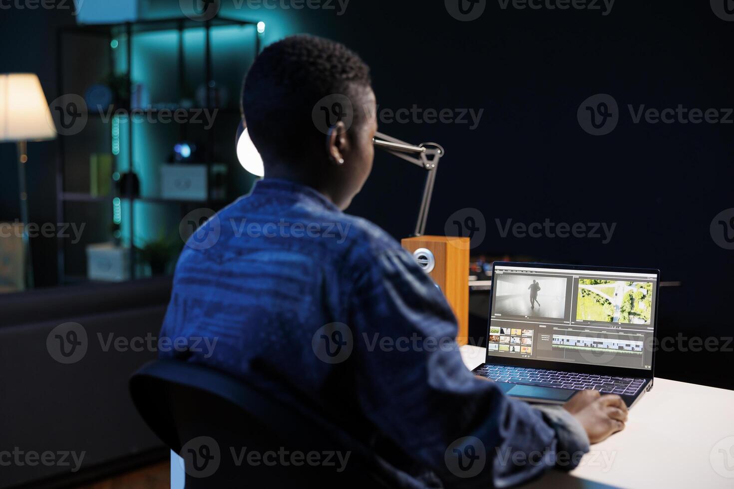 African american filmmaker engrossed in her personal computer, editing and creating multimedia content. Image showing black woman sitting and working on digital laptop, analyzing footage. photo