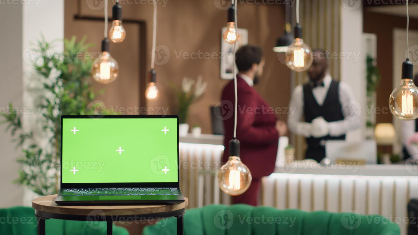 Laptop with blank greenscreen template near hotel reception front desk, people arriving in lobby travelling for work. In luxury resort, businessmen attending official conference. photo