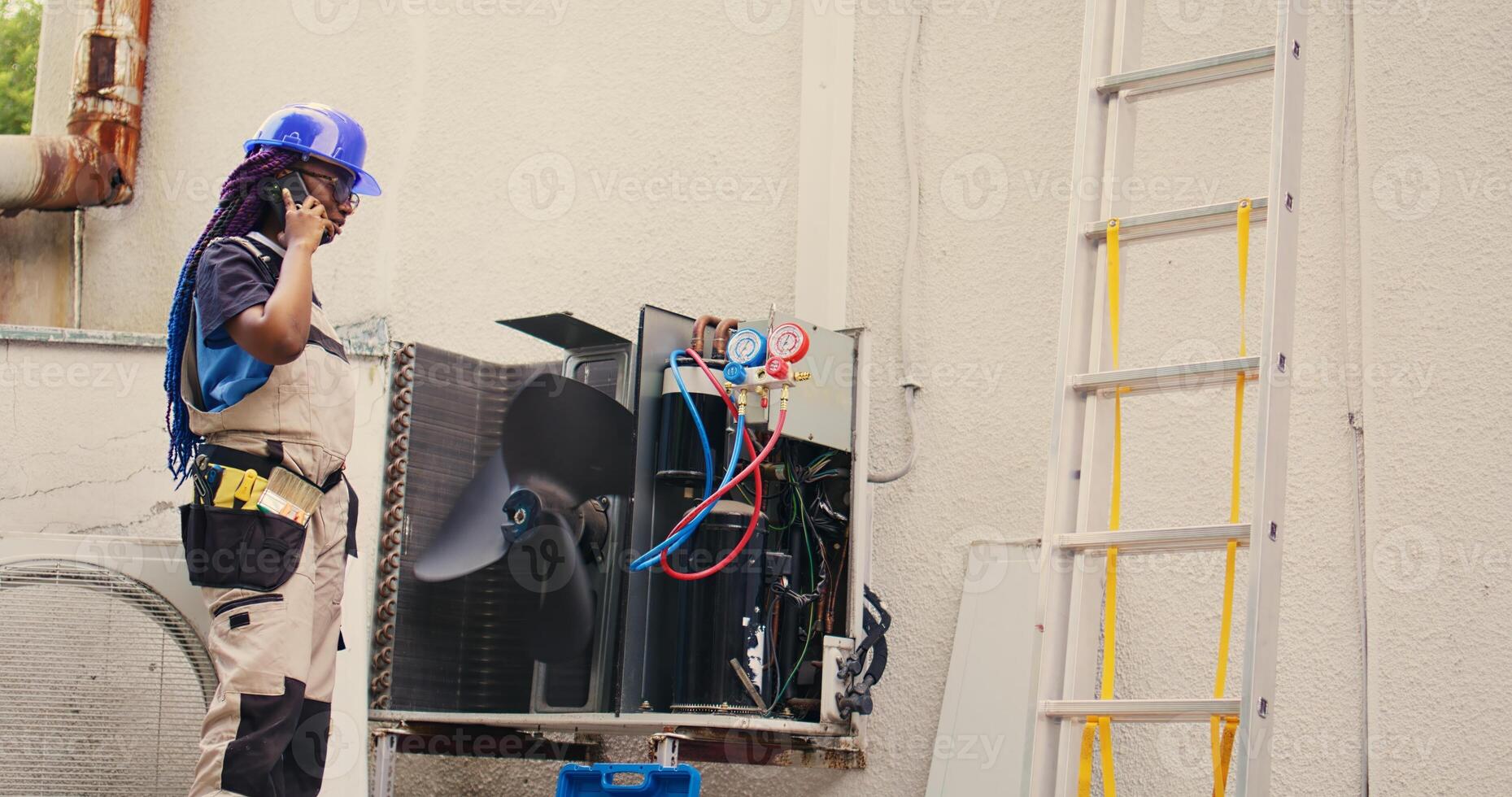 Capable specialist on the phone with home owner after finishing hvac system repairments. Proficient worker calling client to inform him about built up layers of dirt found on air conditioner unit photo