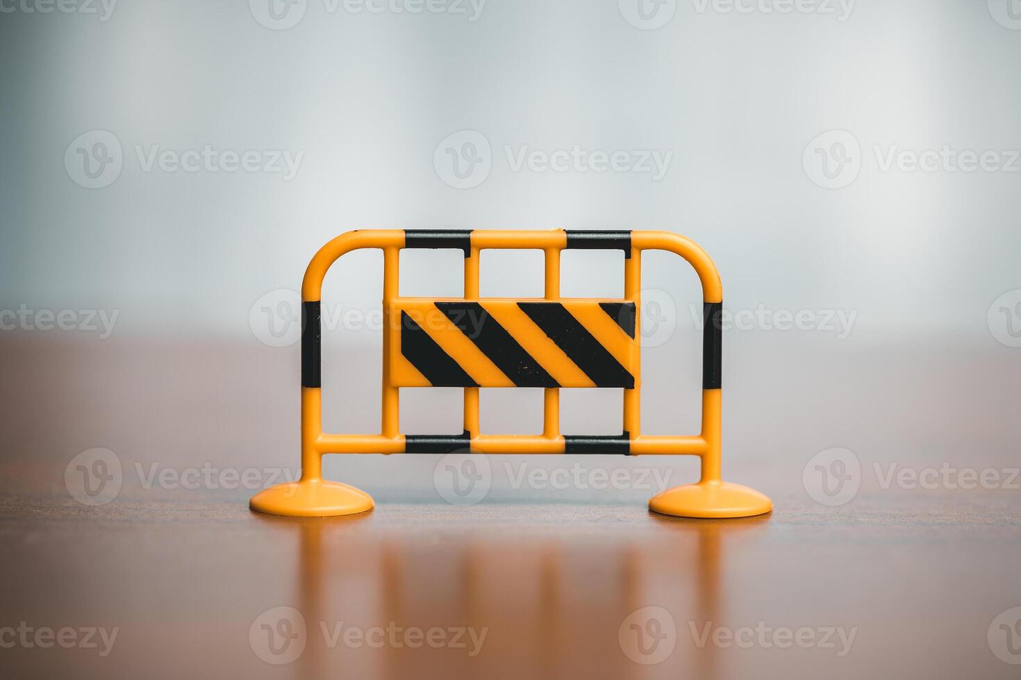 Traffic barrier on the wooden floor in front of a blurred background. photo