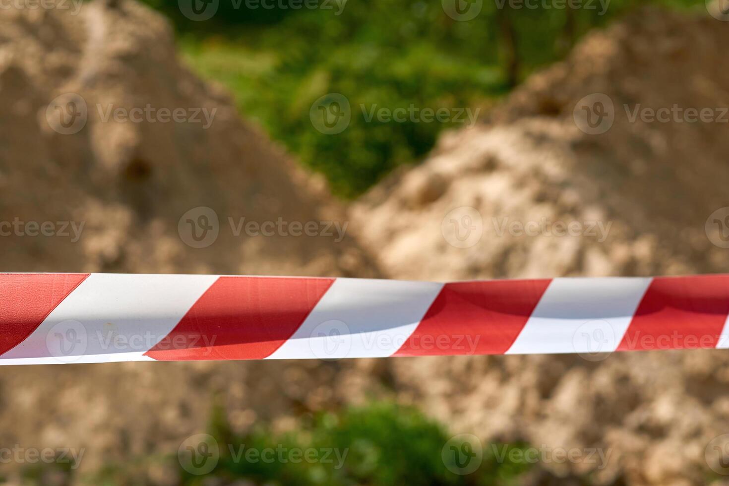 Red and white fencing tape warning of danger during construction and repairs photo