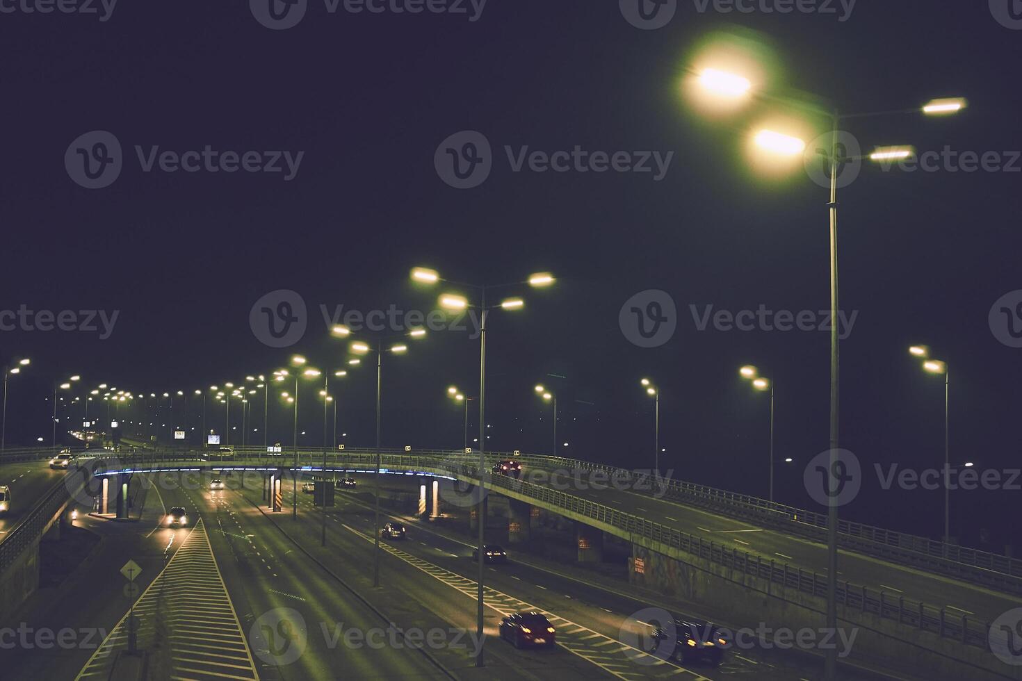 City traffic of cars on wet night street with glowing lights photo