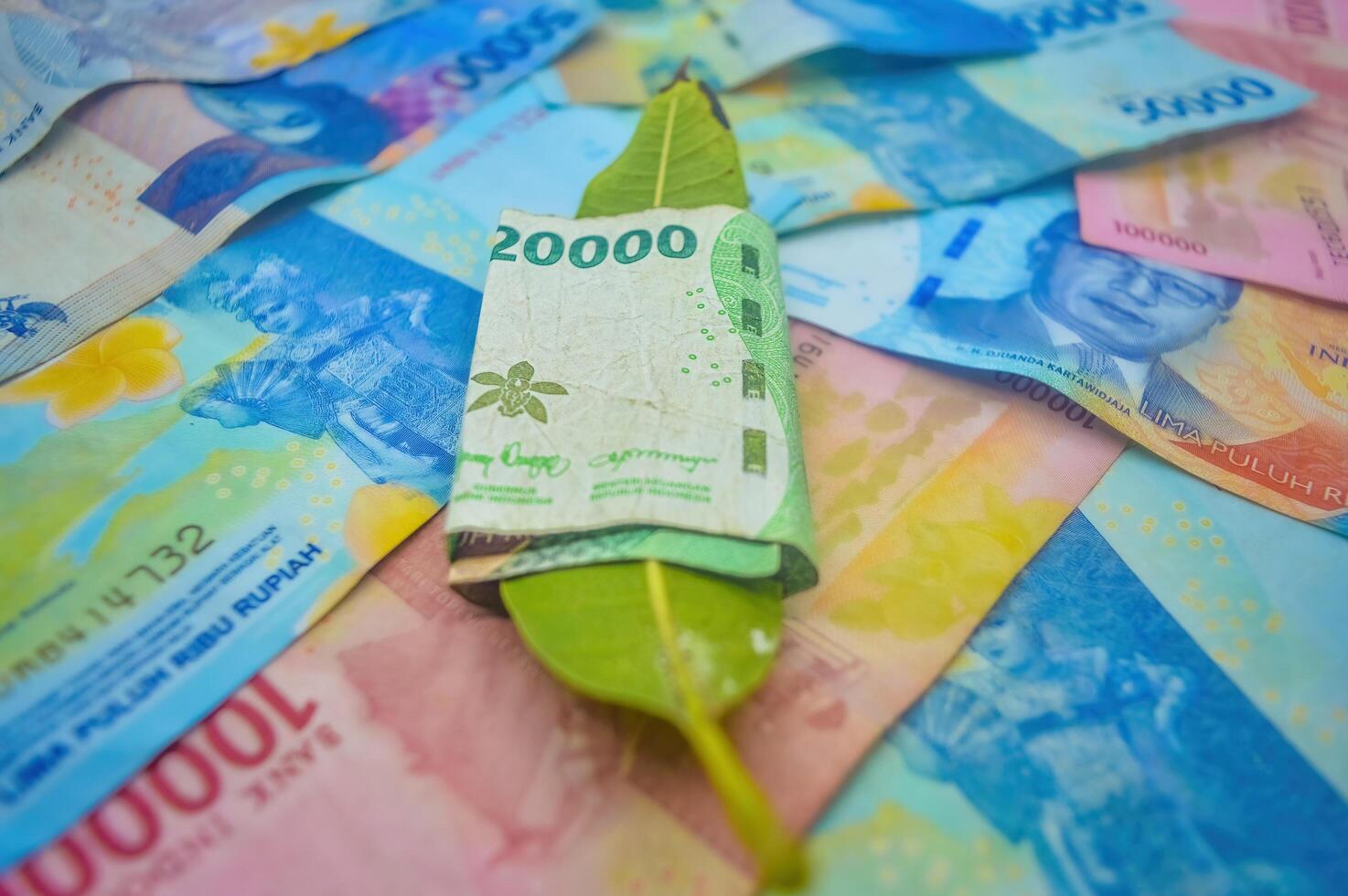 leaves wrapped in money stacks of rupiah notes photo