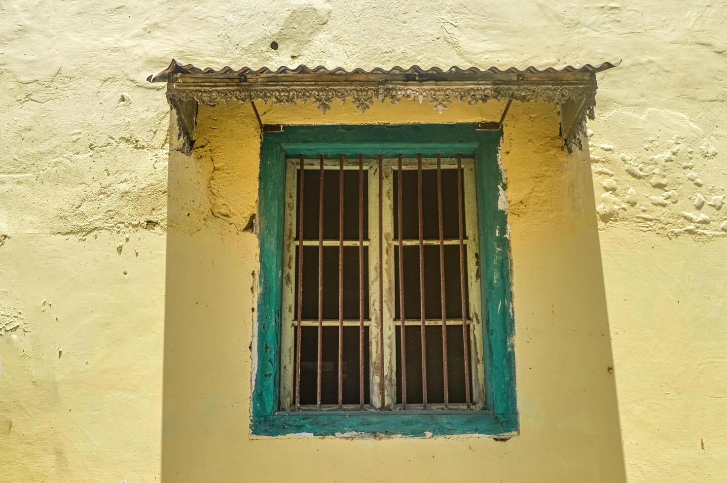 un verde de madera ventana con hierro barras en un antiguo holandés casa en Indonesia foto